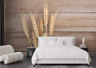 A handful of golden wheat ears on wooden planks background Wall mural