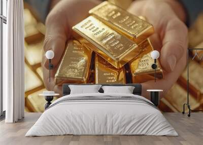 A close-up of hands holding multiple small gold bars, symbolizing wealth, finance and gold investment. Wall mural