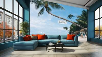 A serene tropical beach scene on Koh Samui, Thailand, with clear blue skies, calm ocean waters, and a leaning palm tree. Wall mural