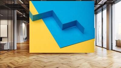 Abstract minimal paper background. Blue zig zag cut out paper stripe on blue and yellow paper background. Wall mural