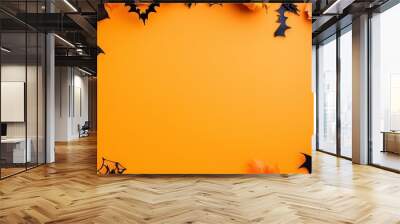 Spooky Halloween decorations set on vibrant orange paper in a flat lay top view, featuring a frame of carved pumpkins, spider webs, bats, ghost eyes, and a skeleton head. Perfect for creating eerie ba Wall mural