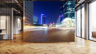 asphalt road near skyscrapers at night Wall mural