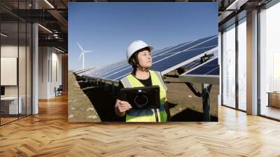 female technician working with tablet in solar power station Wall mural