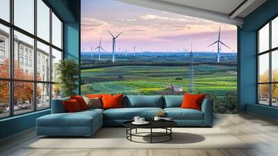 view of wind power turbine and steel tower in field at sunset Wall mural