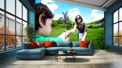 The boy gives his mother a bouquet. Wall mural