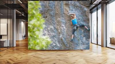 The climber is training to climb the rock. Wall mural