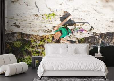 The girl climbs the rock. Wall mural