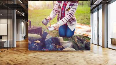 The girl prepares coffee in nature. Wall mural