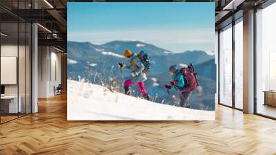 Tourists travel together in the mountains in winter. two girls snow-capped mountains. Wall mural