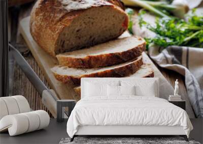 Sliced traditional artisan, sourdough bread on a wooden board, close-up view Wall mural