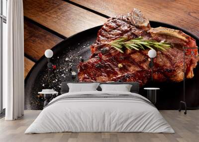 Grilled beef steak with rosemary, salt and pepper on black stone plate. Grilled striploin sliced steak. Juicy thick grilled beef steak seasoned with rosemary fresh of the summer BBQ. Wall mural