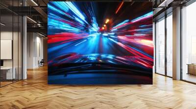 A blurry view of a car driving at night in a city, with streaks of red and blue lights from passing cars and street lights. Wall mural