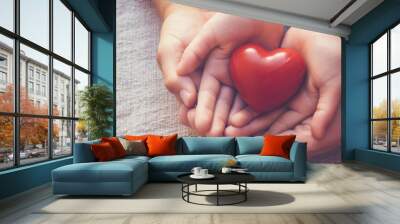 adult and child hands holding red heart, heart health, world heart day,Ai generated Wall mural