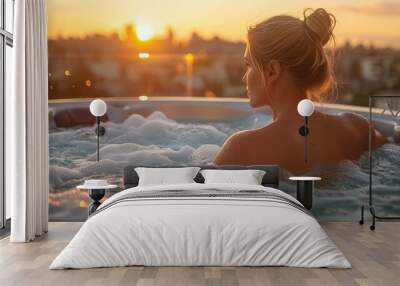 A serene blonde model enjoying a spa hot tub during twilight with last sun rays and busy city skyline in background Wall mural