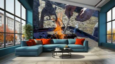 Horseshoe being forged in an open coal pit outside. Wall mural