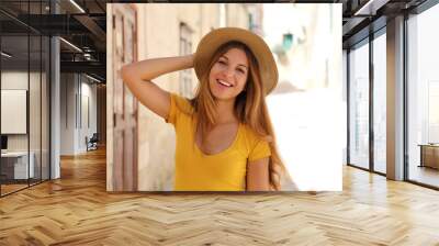 Attractive smiling young tourist woman with straw hat on a sunny day of summer on holidays Wall mural