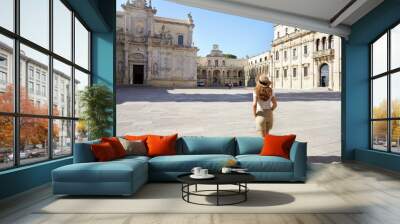 Cultural tour in Italy. Full length of young pleasant tourist woman in the baroque city of Lecce, Italy. Wall mural