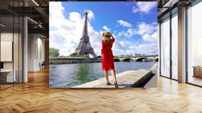 Tourism in Paris, France. Back view of young woman visiting the city of Paris with Eiffel Tower and Seine River. Wall mural