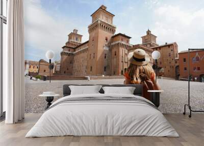 Travel in Italy. Rear view of traveler girl walking towards Este Castle (Castello Estense) of Ferrara, Italy. Wall mural