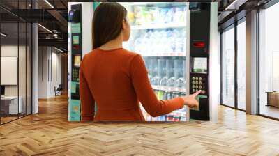 Young traveler woman choosing a snack or drink at vending machine in airport. Vending machine with girl. Wall mural