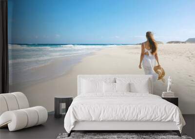 Young woman walking on empty wild beach with white sand and blue sky in Corralejo, Canary Islands Wall mural