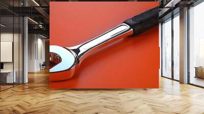 Chrome Wrench with Black Handle on Orange Background Wall mural