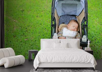 Asian baby boy sleeping in stroller on nature park. Wall mural