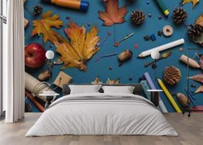 A flat lay showcasing a yellow school bus toy, fall leaves, pencils, pine cones, and other autumnal decor Wall mural