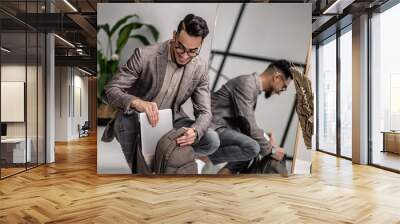 A stylish man apacking his backpack before leaving to work Wall mural