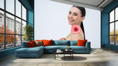 Beautiful tender young woman with a flower in hand looking relaxed Wall mural