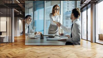 Best cooperation. Charming young woman carrying out a meeting with her companys business partners and shaking hands with a new one Wall mural