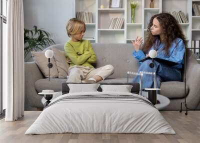 Blonde boy talking to a speech therapist before the beginning of session Wall mural