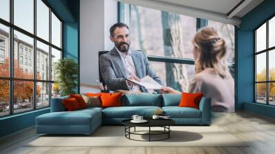 Business man taking documents from female assistant Wall mural