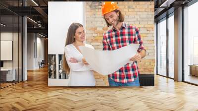 Construction worker in orange helmet and a customer discussing the project design Wall mural