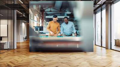 Dark-skinned writer working with his assistant in printing office Wall mural