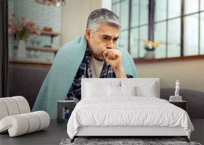 Depressed cheerless ill man having cold symptoms Wall mural