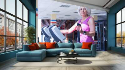 Elderly woman working out at gym Wall mural