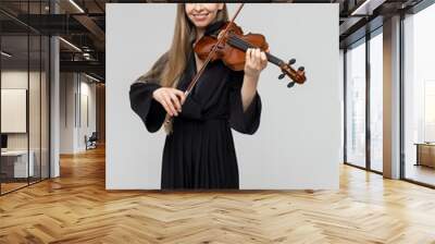 Elegant woman playing violin wearing black attire Wall mural