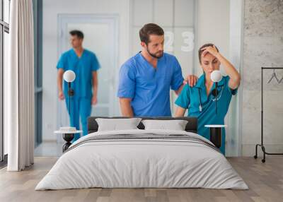 Female doctor feeling happy while her male colleague supporting her Wall mural