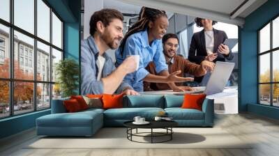 Group of diverse businesspeople using laptop while working together Wall mural