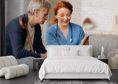 Joyful excited nurse explaining something to her patient Wall mural