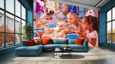 Kids eating pizza. Calm thoughtful children attending birthday party and eating pizza at the big table Wall mural