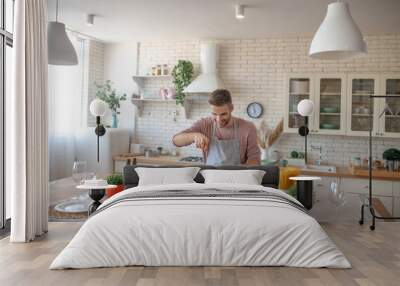 Man enjoying cooking time in his spacious modern kitchen Wall mural