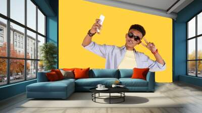 Popular blogger. Joyful stylish man wearing sunglasses while taking a selfie Wall mural