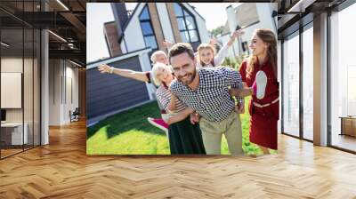 Watching you. Cheerful bearded man keeping smile on his face while looking at camera Wall mural