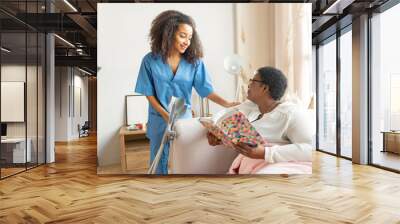 Woman wearing glasses reading the book and talking to nurse Wall mural