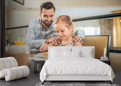 Young father having a breakfast with his daughter Wall mural