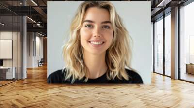 A natural light portrait photo features a young woman with wavy blonde hair and a warm smile, expressing friendliness and approachability. It's vibrant and contemporary. Wall mural