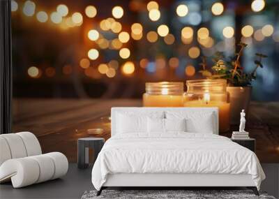 Small jars with candles in them on a wooden table with a blurred background Wall mural