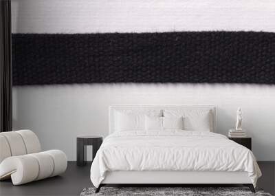 Closeup of a woven black fabric strip used in fashion and clothing Wall mural